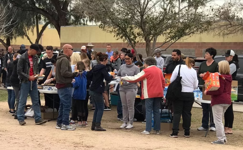Volunteers at a Tuesday Night ministry event distribute food and clothes, offering support to participants in need.